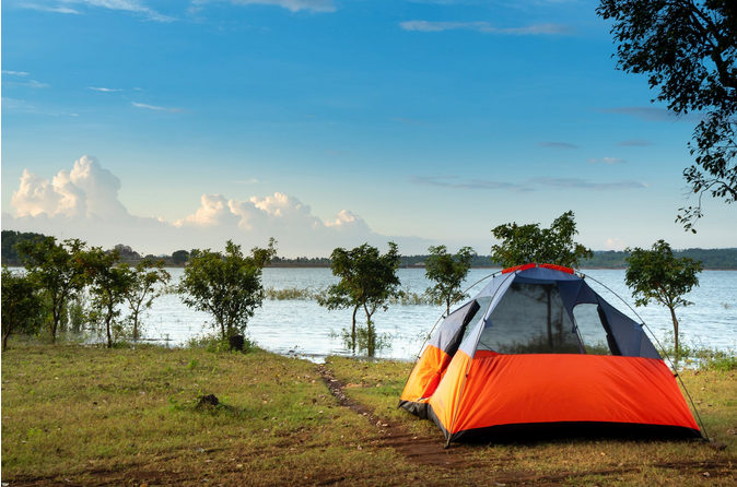 a camping tent by a lake